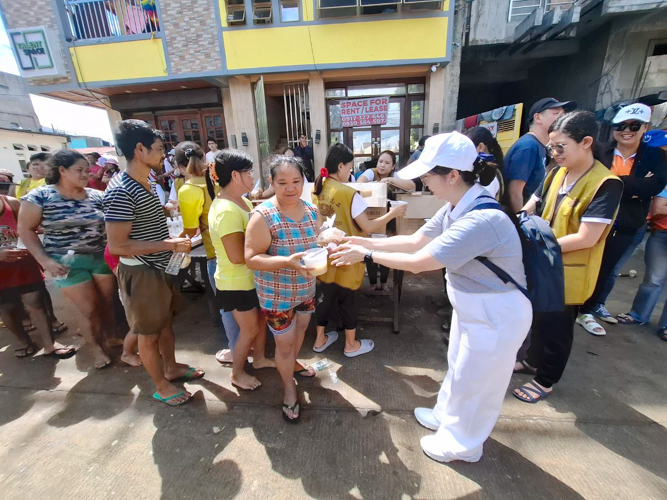 Tzu Chi Bicol volunteers distribute hot meals to affected residents of Barangay San Roque.