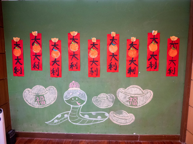 Preschoolers paint their own red scrolls bearing positive messages for the Year of the Wood Snake. 