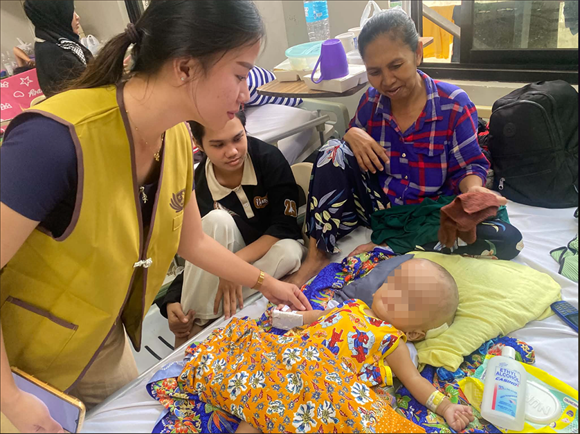 Trisha Padilla checks on a child with hydrocephalus. “Even though I struggle, there are others who are struggling more,” she said. 