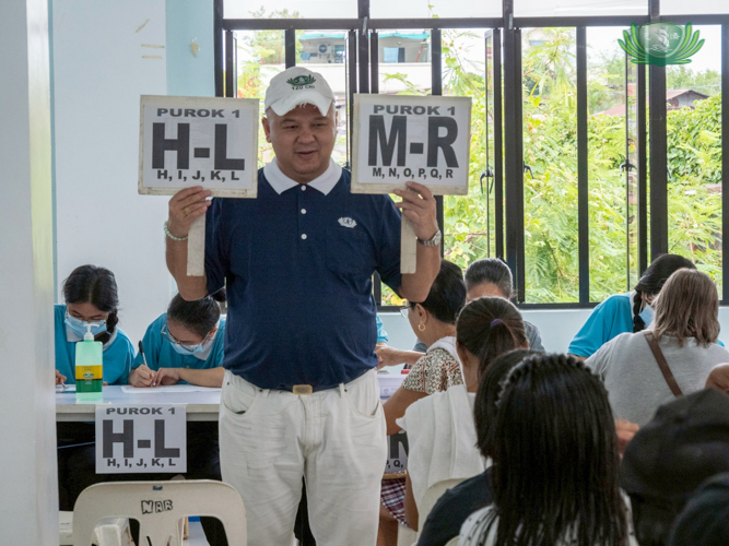 Tzu Chi volunteer Scott Wu helps organize the stub distribution.