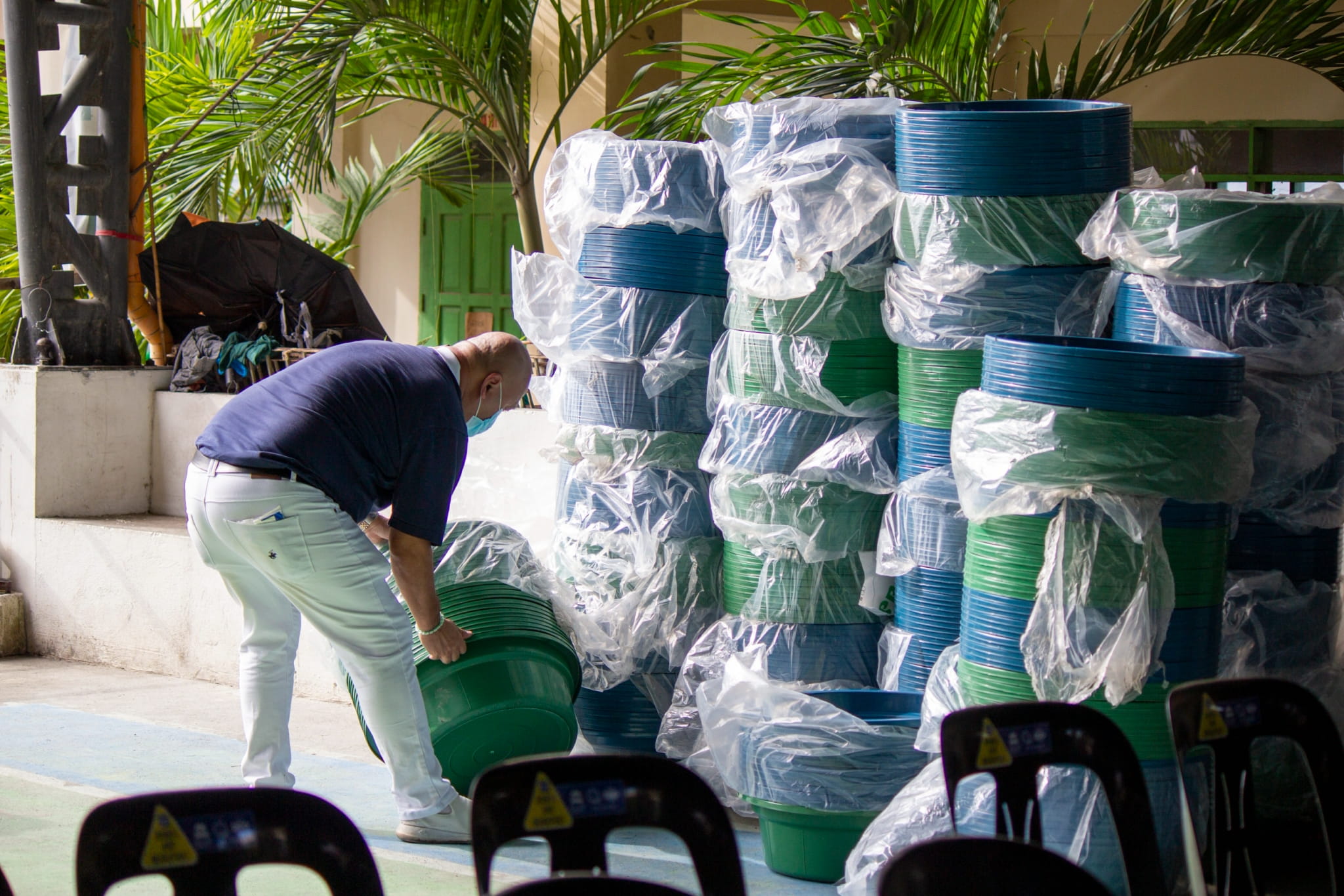 Tzu Chi volunteers arrange water jugs and basins in preparation for the relief distribution.