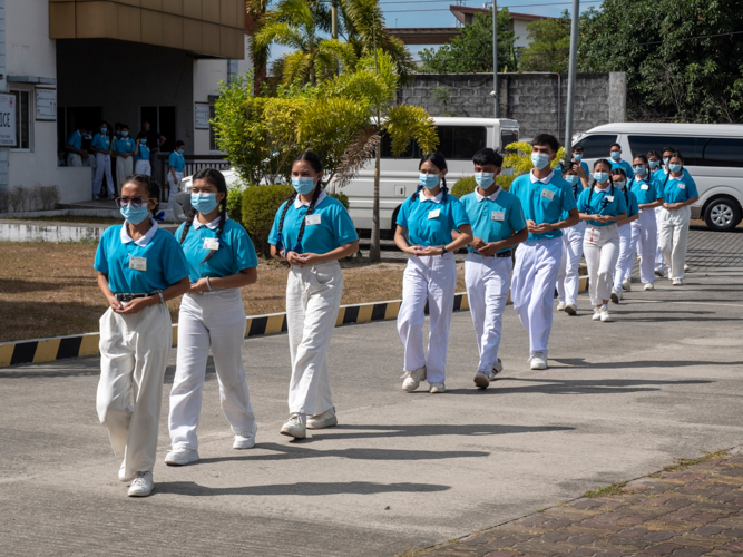 Tzu Chi scholars make their way to meet the beneficiaries gathered under the facility’s shelter.