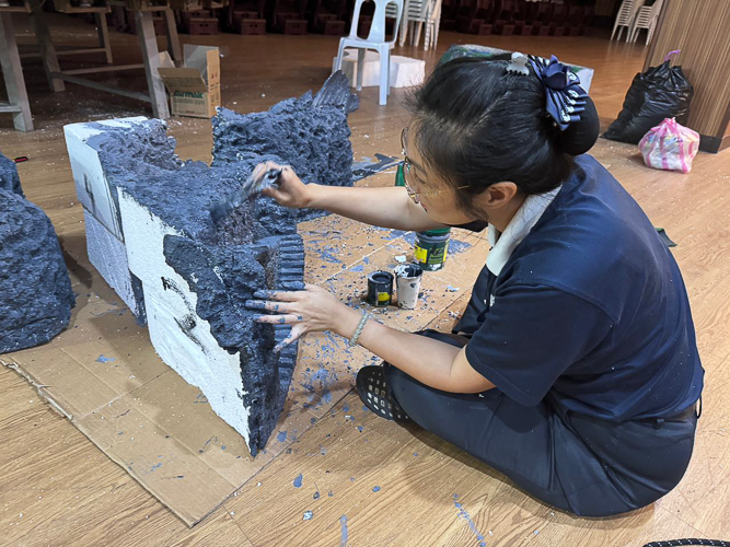 Styrofoam is surprisingly versatile. Here, a Tzu Chi volunteer chips away at the Styrofoam with a cutter to give it a rugged texture. 