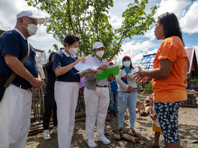 Romelina Añabieza from Barangay Sto. Niño (right, in orange) recounts her traumatic experience surviving the storm. 【Photo by Marella Saldonido】