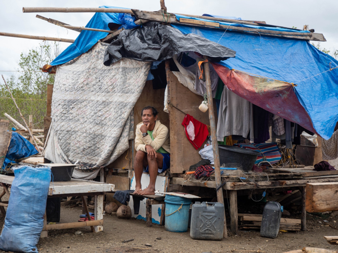 A man ponders his fate and future from the remainder of his home in Tubigon. 【Photo by Marella Saldonido】