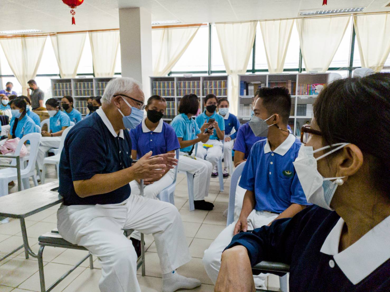 In Bohol, Tzu Chi scholars listen as a volunteer explains relief operations. 