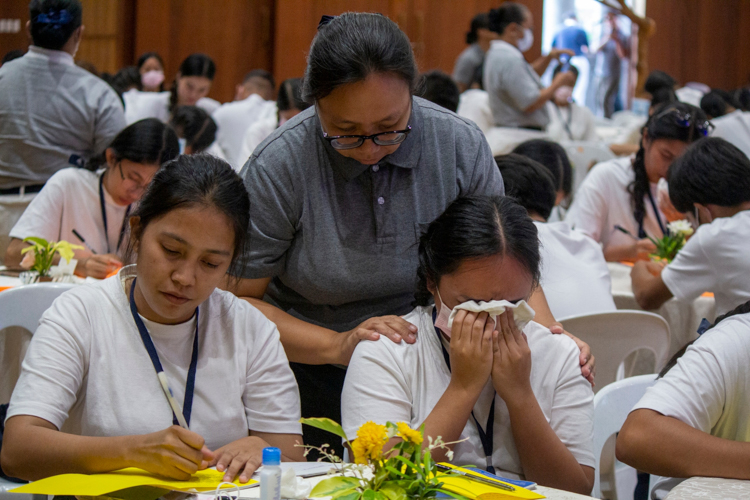 In an emotional letter-writing activity to their parents, scholars are comforted by volunteers.