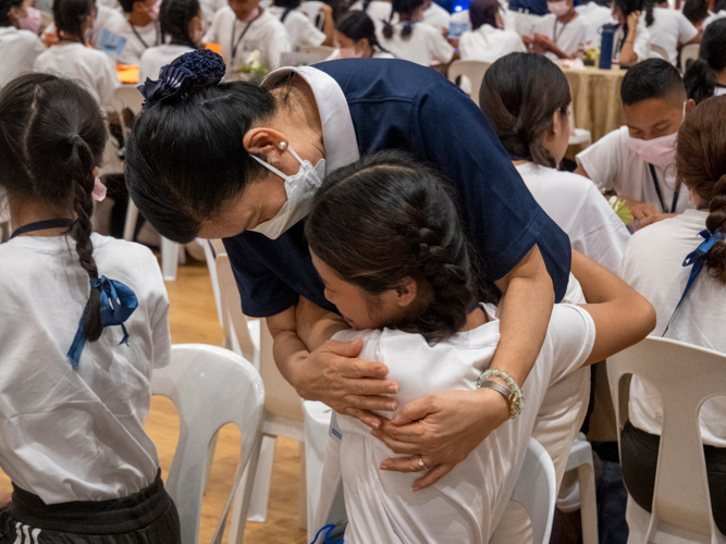 In an emotional letter-writing activity to their parents, scholars are comforted by volunteers.