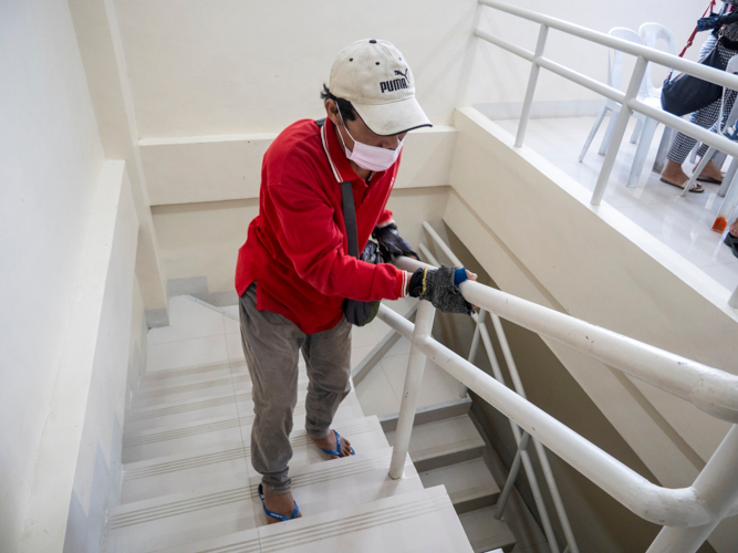 Arnel Arabejo makes his way up a flight of stairs with difficulty. Three sessions of acupuncture from Tzu Chi’s medical mission would improve his walking.