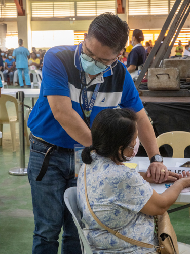 A volunteer doctor assists a general medicine patient with her medical concerns.