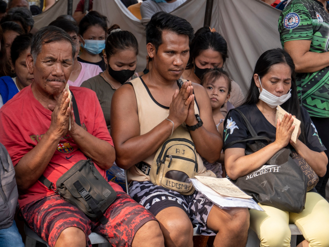 Oroquieta residents pray before the start of relief distribution. 【Photo by Matt Serrano】