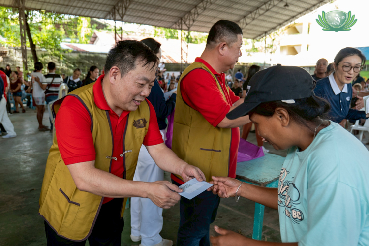 PCCCI member Jet Lee (left) happily takes part in distributing grocery vouchers to beneficiaries.