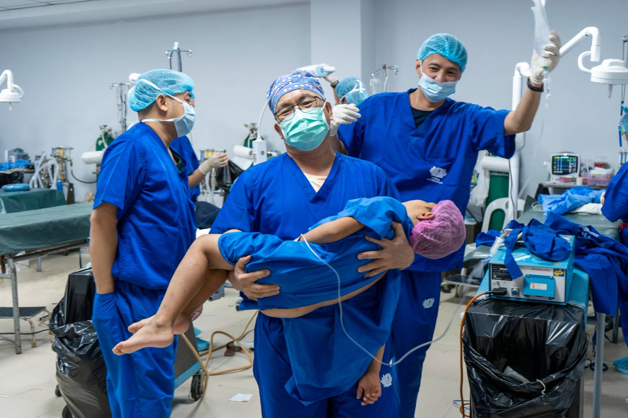 All done! A TIMA doctor carries a child to the post-anesthesia care unit following a successful herniorrhaphy. 