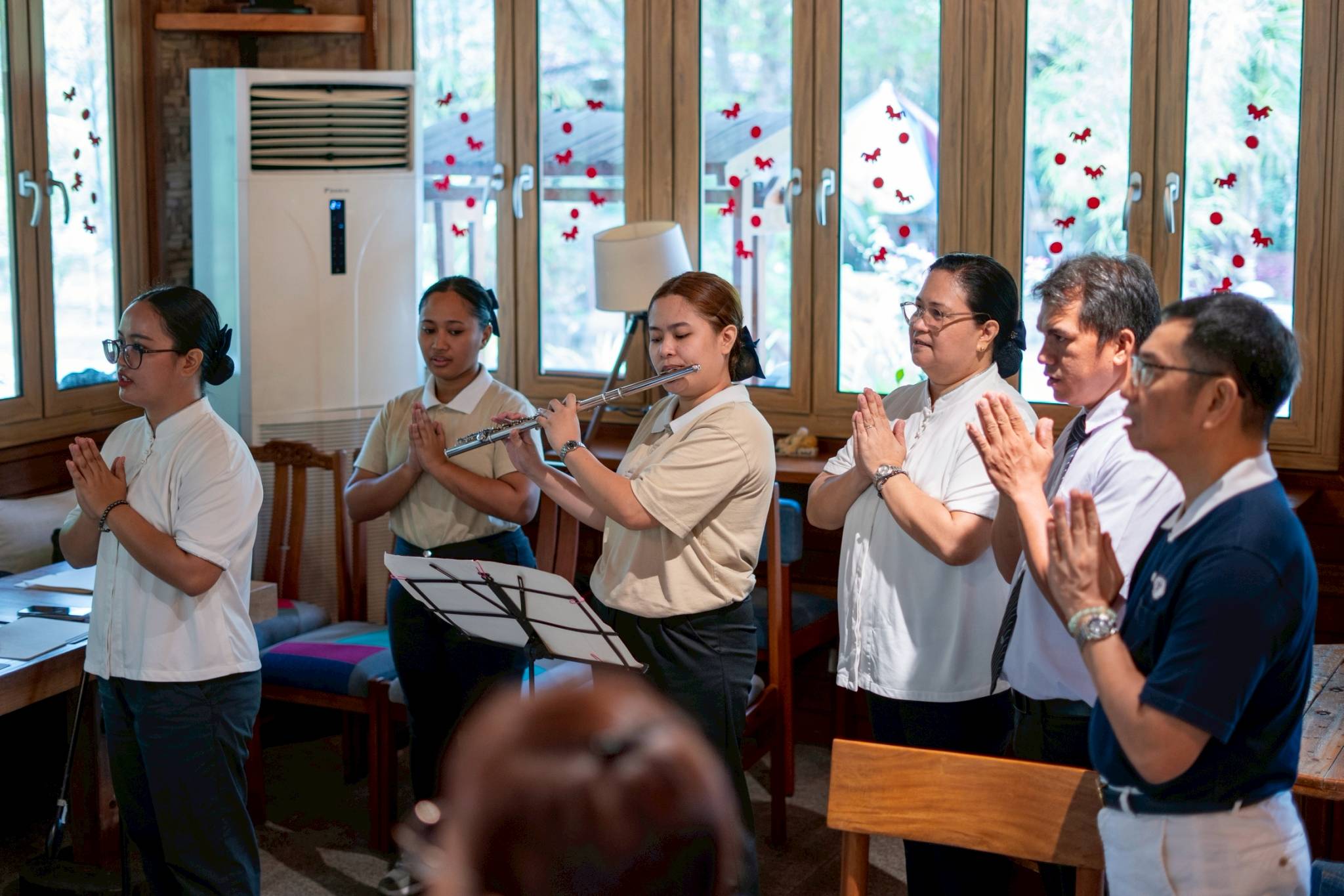 Caregiving scholar Jasmine Bailen accompanies the singing of the Tzu Chi Prayer on flute.