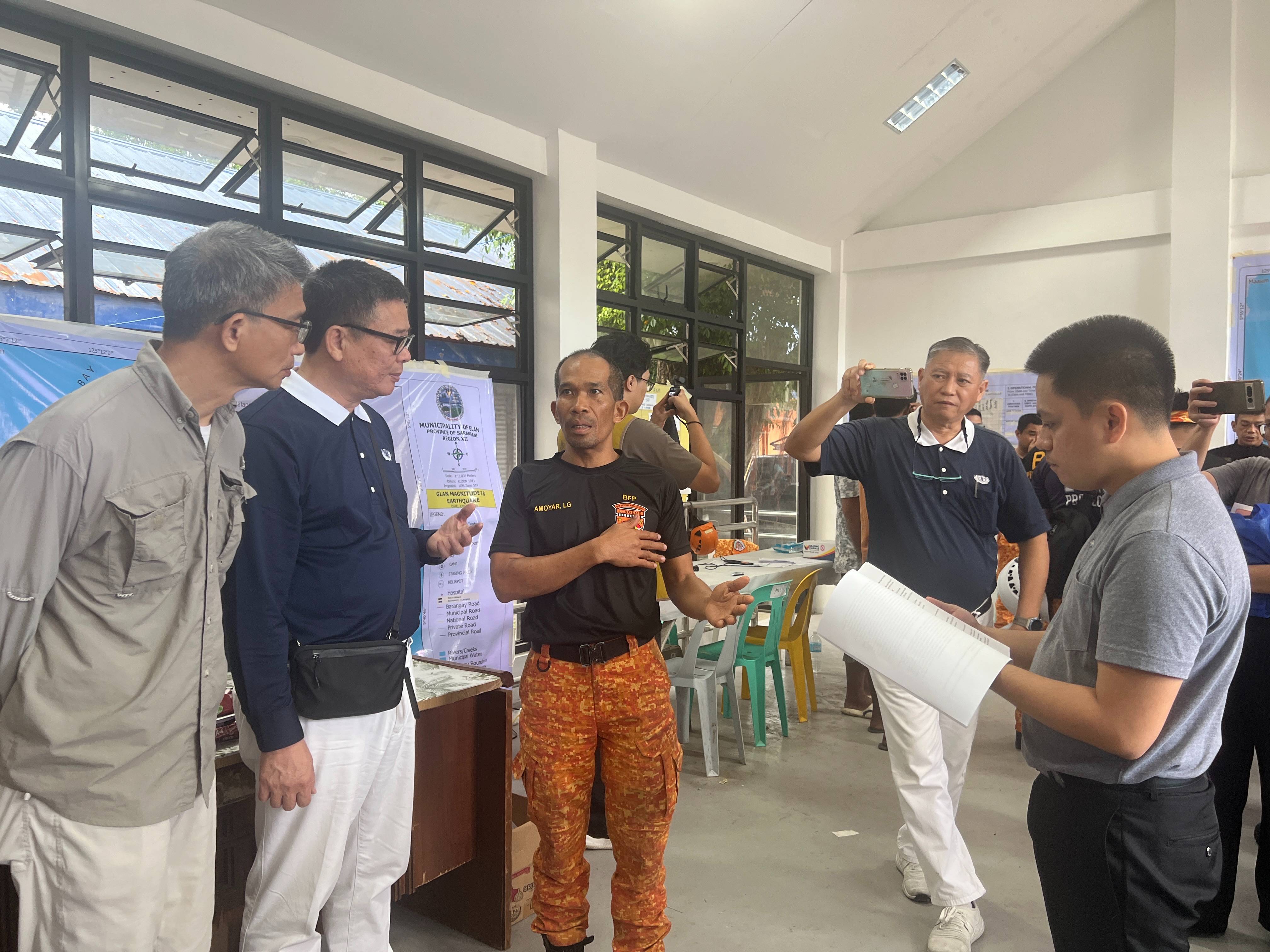 At Glan’s command center, volunteers get updates from Bureau of Fire Protection (BFP) Fire Superintendent Lowyn G. Amoyar (third from left). Together with his team, the acting chief of BFP Region XII Special Rescue Force was sent to Glan to assist with search, rescue, and recovery efforts.