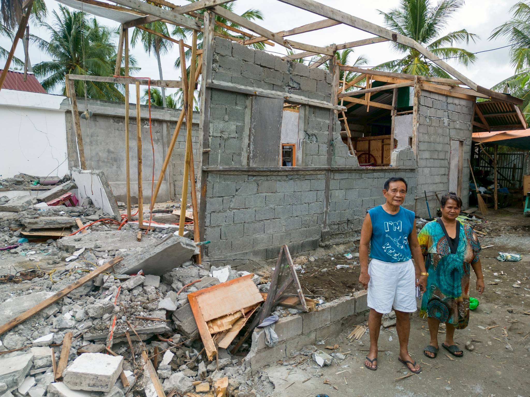 Rodrigo Masurin Moda Sr. and his wife Inriza stand before their damaged home in Barangay Kalbay. 