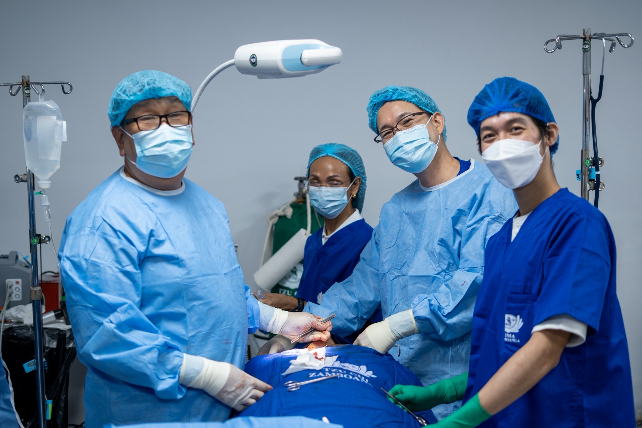 Doctors pause briefly from a surgical procedure to have a photo taken. 