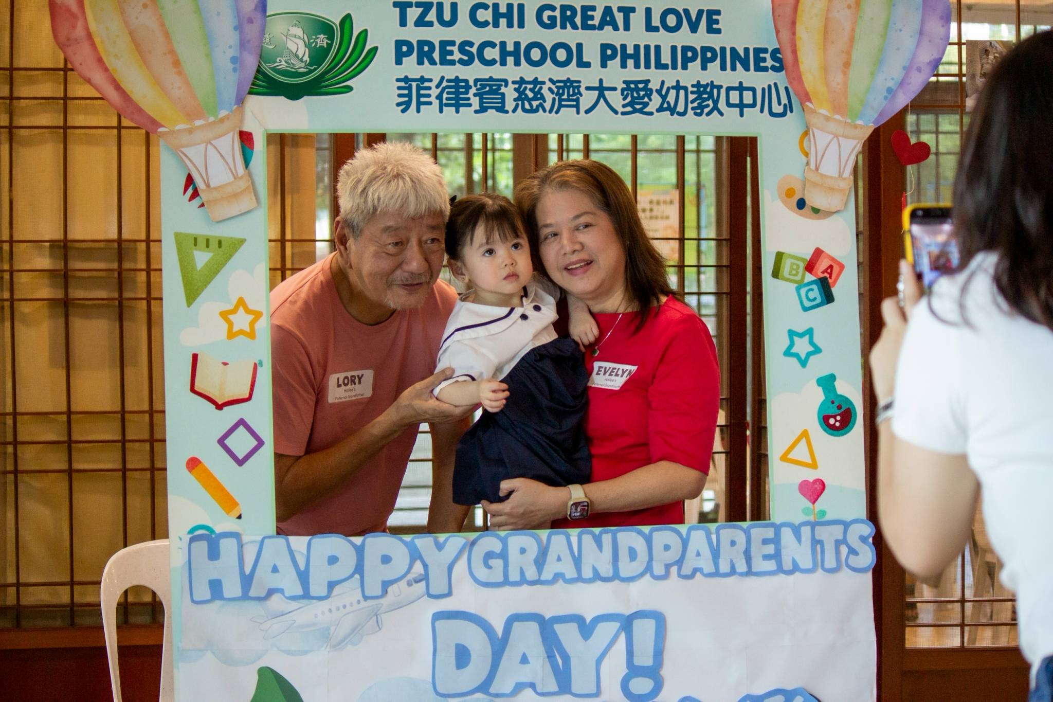 Smiles all around as families strike a pose inside the custom photo frame cutout.