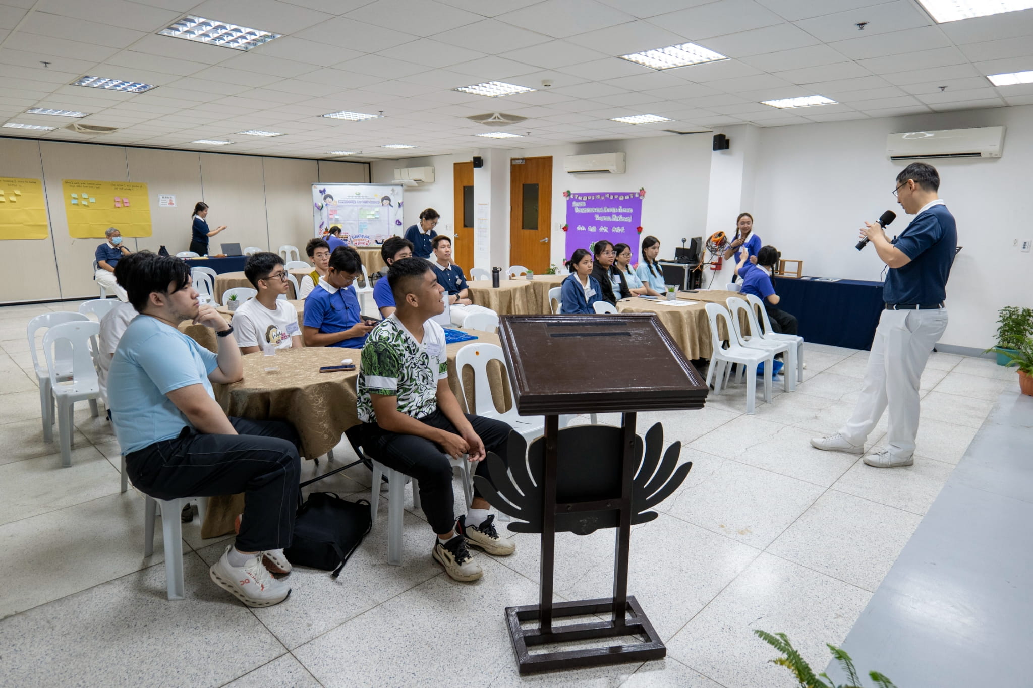 Tzu Chi Malaysia volunteer Jia Jiann Foo (standing, right) explains what it means to be a Tzu Ching to newly inducted members.