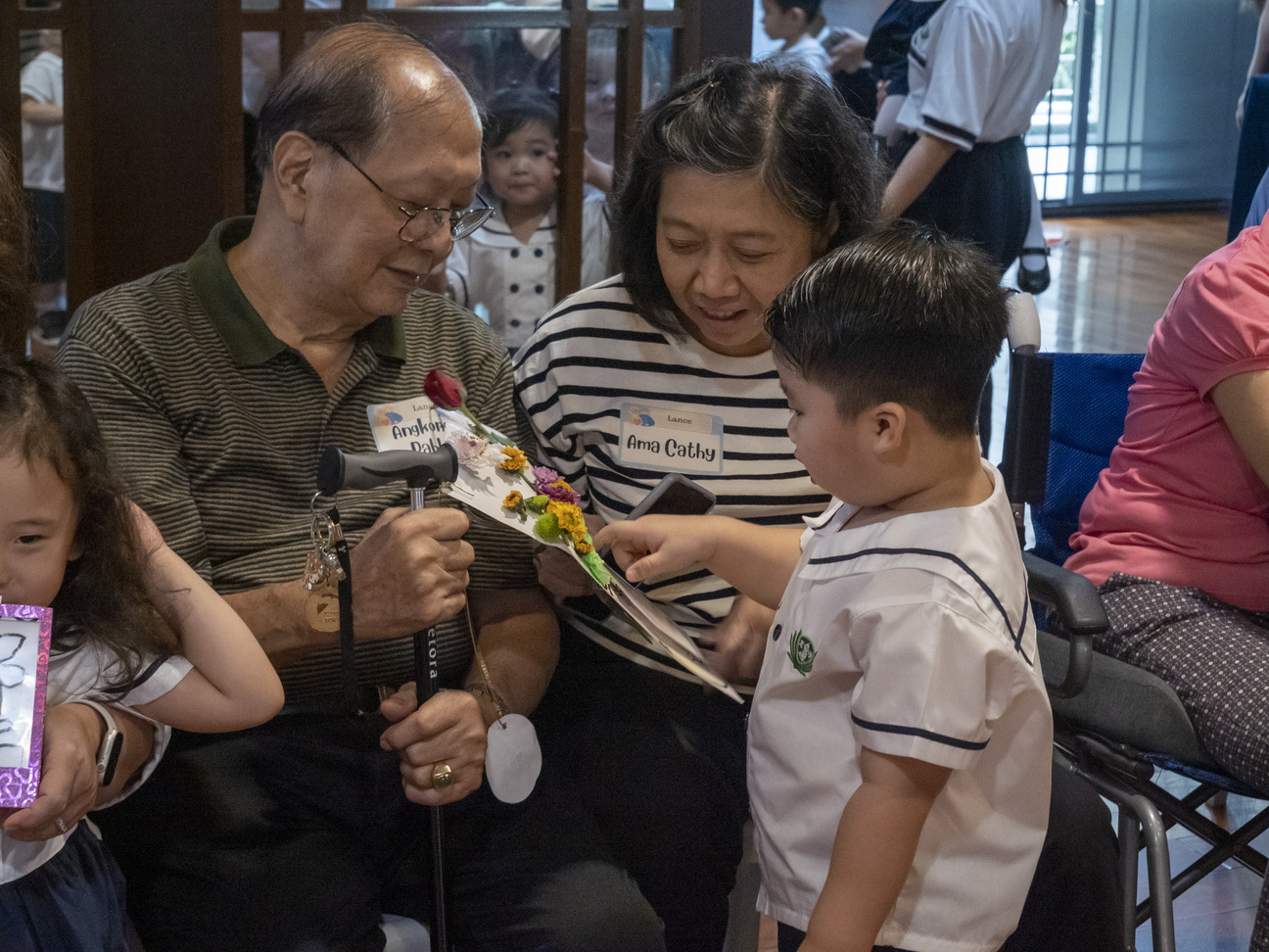 Grandparents happily look at their grandchildren’s work of art.