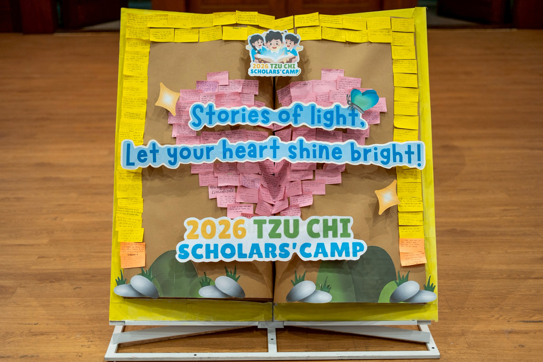 A board shaped like an open book carries scholars’ handwritten expectations of the three-day camp.