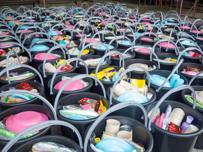 Tondo fire victims are given a pail containing a blanket, sleeping mat, laundry bleach, detergent soap, shampoo, body wash, cooking oil, vinegar, salt, soy sauce, condensed milk, sugar, and biscuits as relief items.