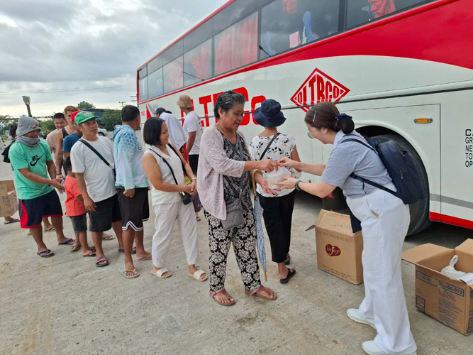 Tzu Chi Bicol volunteers hand out hot meals to stranded passengers on the road.