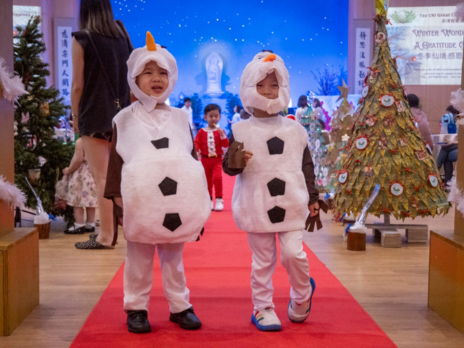 Nursery and pre-kindergarten students came in their best holiday clothes, with these two wearing a famous snowman costume.