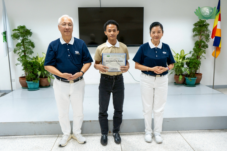 With Tzu Chi volunteer James Cheng (left) and Education Committee Head Rosa So (right), Abdul Karim Madale marks a moment of gratitude for the opportunity to continue his education.