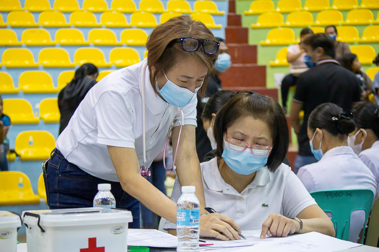 Dr. Rose Go (left) works with a fellow doctor in assessing patients. 【Photo by Marella Saldonido】