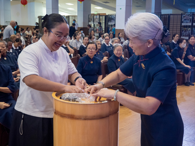 In a moving display of collective generosity, attendees contribute their donations to the bamboo banks, each coin representing their support to Tzu Chi’s mission of compassionate service.