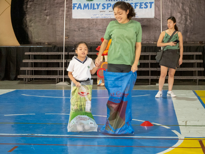 A mother-and-daughter duo competes in the sack race portion of the game.