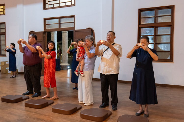 In a moment of spiritual unity, Tzu Chi volunteers, guests, and families gather inside the serene Jing Si Abode for prayer and reflection.