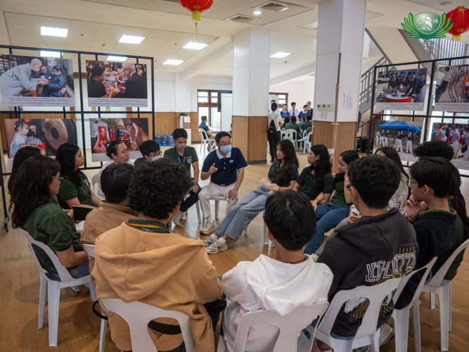 A Tzu Chi volunteer facilitates a group discussion with the students.