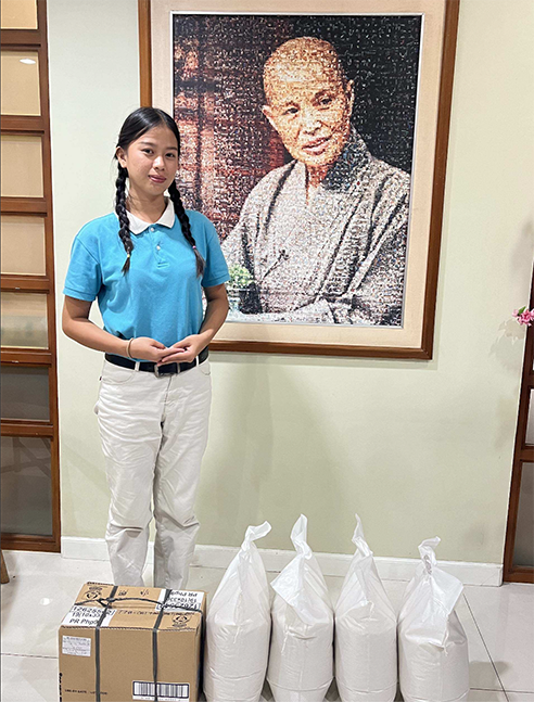 Standing next to a portrait of Tzu Chi founder Dharma Master Cheng Yen, Trisha Padilla is grateful for the scholarship that shoulders her education, provides her with some of the basic needs of her family, and makes her part of a welcoming and supportive community. 