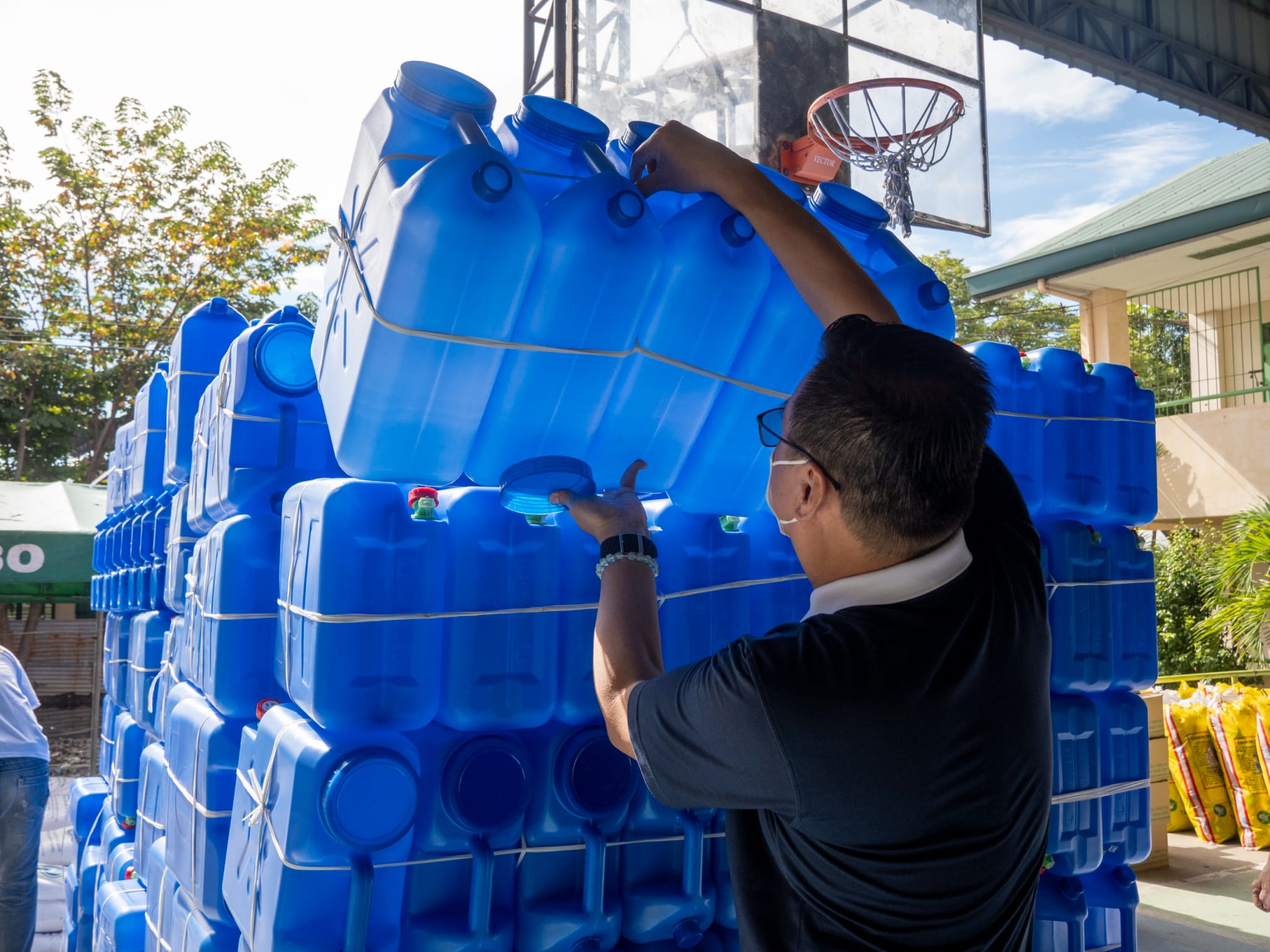Tzu Chi volunteers arrange water jugs and basins in preparation for the relief distribution.