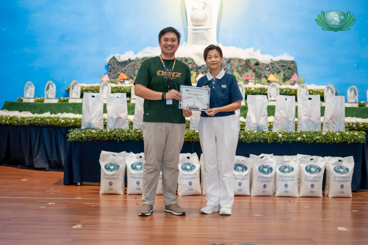 Globe Telecom Sustainability and Social Responsibility Manager Mark Alcantara (left) accepts a certificate of appreciation from Tzu Chi volunteer Molita Chua. Globe’s hunger-alleviating program, Hapag Movement, sponsored the sacks of rice and assorted groceries received by medical assistance beneficiaries who attended Charity Day.