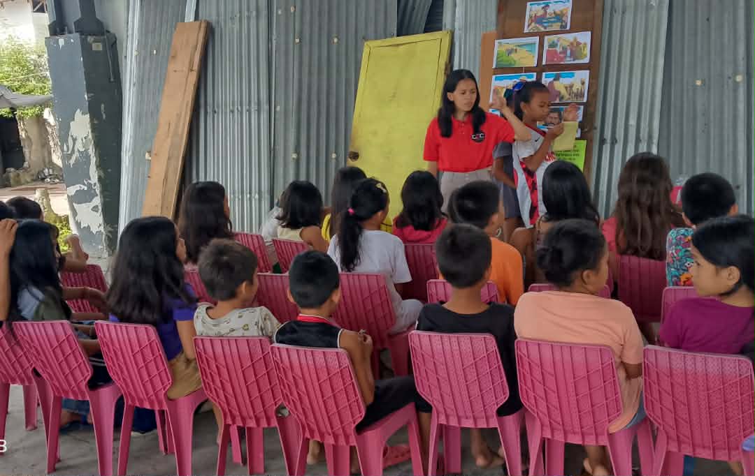 (Standing, in red) Guiding youngsters in an outreach activity in Sabroso Street, Ecoland, Davao City / Photo courtesy of Mira Pondol