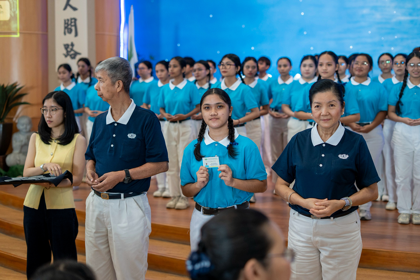 Tzu Chi scholar Jahreez Octaviano receives her scholar ID given by Head Volunteer for Tzu Chi’s  Educational and Medical Assistance Program Rosa So, Tzu Chi volunteer Rudy Ong, and Tzu Chi Charity Run sponsor Lyn Gaw (in yellow).