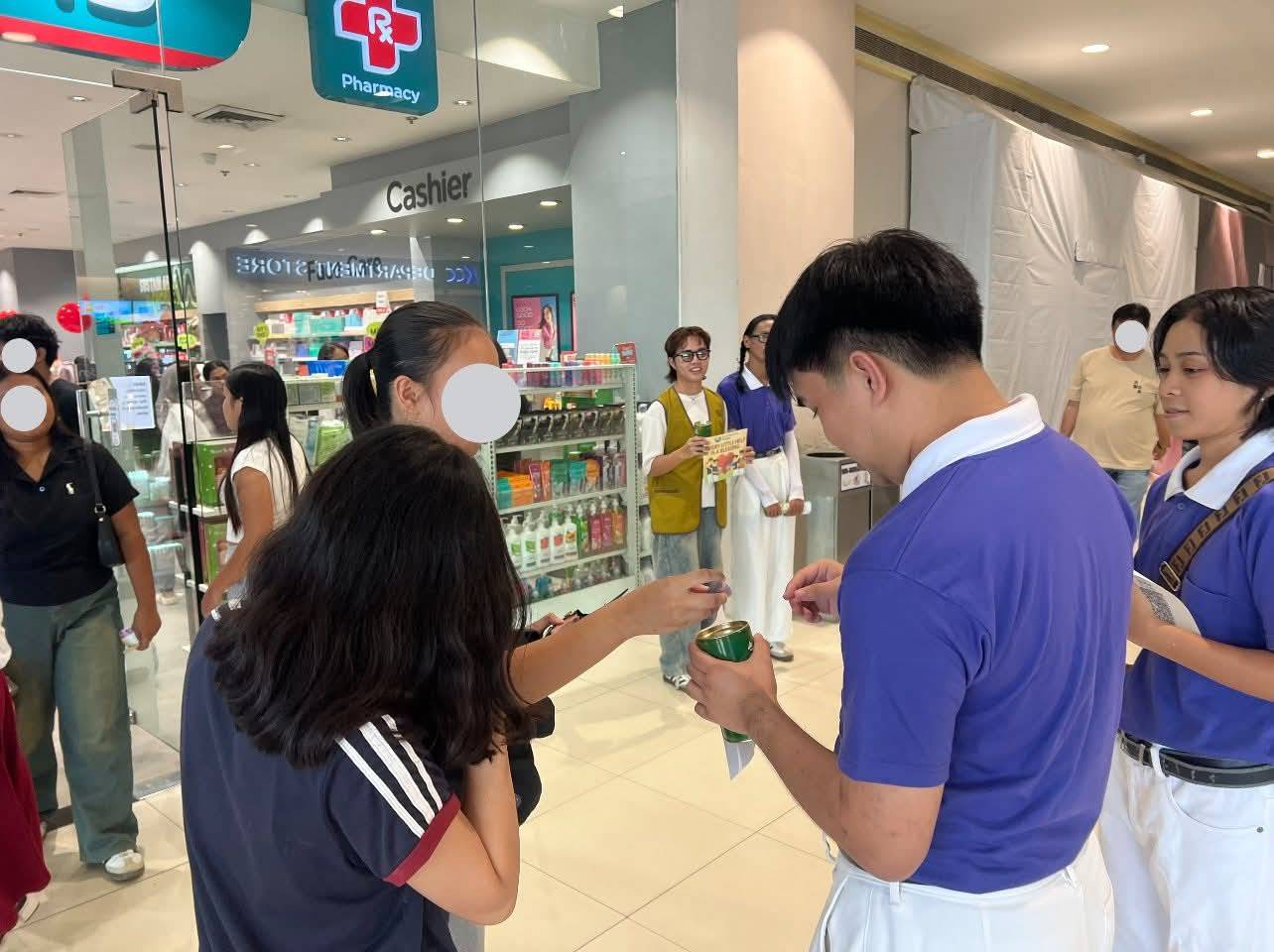 Davidson uses a Tzu Chi coin can to receive donations in a fund-raising initiative for typhoon victims in Cebu. 
