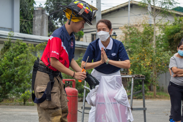 A Tzu Chi volunteer expresses thanks to a fireman for helping her put out a fire from a gas tank. 【Photo by Marella Saldonido】