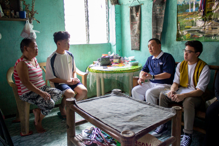 Rizalina Zarceno and her grandson John Gabriel chat with Tzu Chi volunteers during a home visit as part of John’s scholarship application. 【Photo by Marella Saldonido】