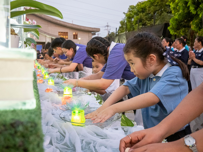 At the Buddha Bathing Ceremony, Tzu Chi scholars and youth touch a bowl with water, a gesture of respect that symbolizes touching the feet of Buddha.