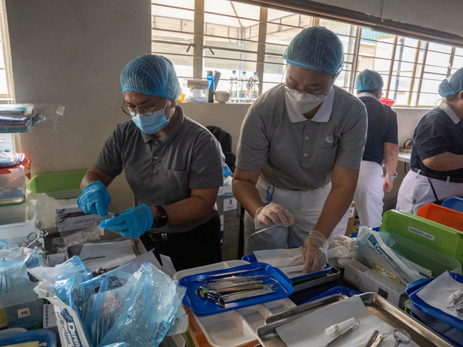 Volunteers at the dental area manage and organize the dental tools used for tooth fillings and extractions.