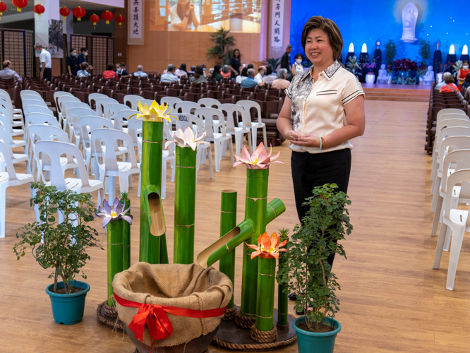At the Jing Si Hall, a guest poses next to a bamboo arrangement where donations are dropped. 【Photo by Matt Serrano】