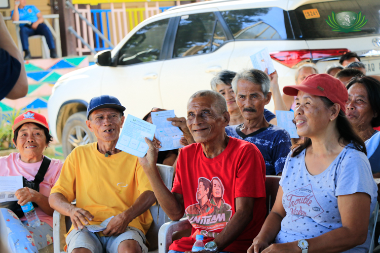 Beneficiaries in Compostela wave their stubs happily as they prepare to claim grocery assistance.