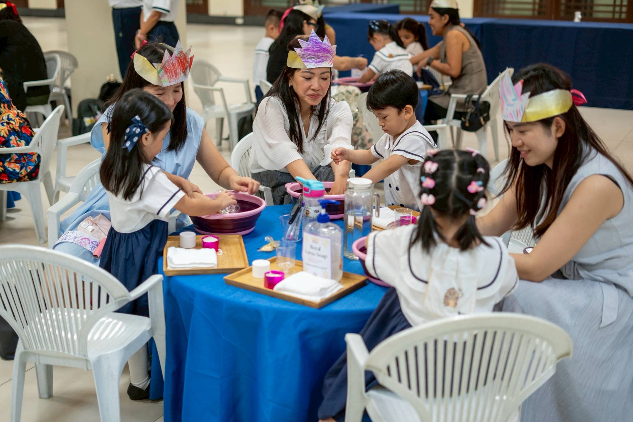 Little massage therapists focused on their task of giving their moms the best hand spa service. 