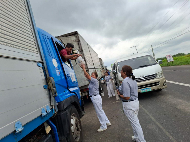 Tzu Chi Bicol volunteers hand out hot meals to stranded truck drivers in Pili, Camarines Sur.