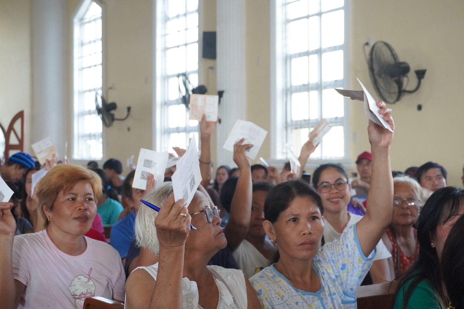 Beneficiaries raise their stubs during the relief distribution.