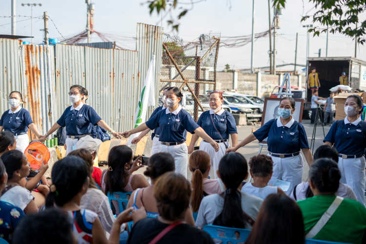 Tzu Chi volunteers perform the sign language of “One Family” and encourage the beneficiaries to hold the hands of their seatmates, indicating that no one should feel alone in the aftermath of the fire.